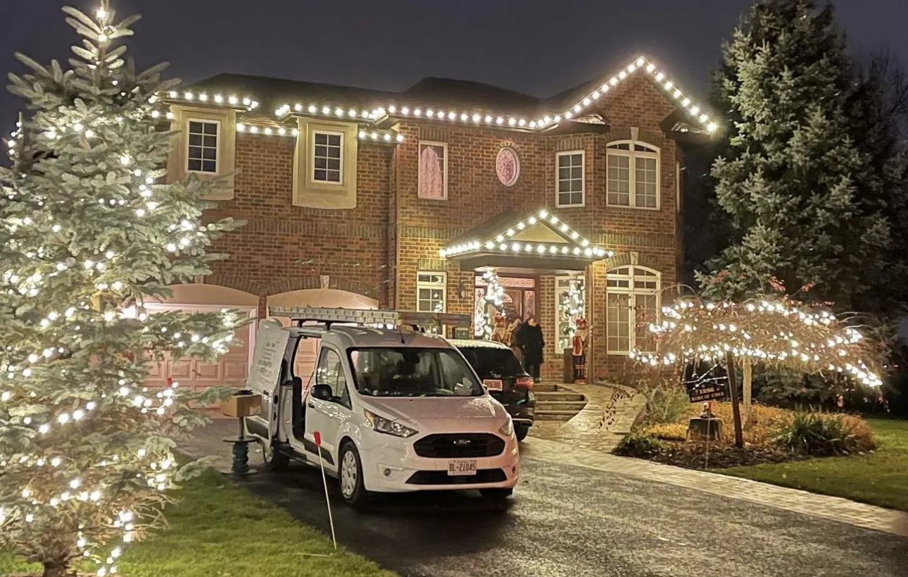 Home front lit with holiday roofline lighting across the peaks and garage